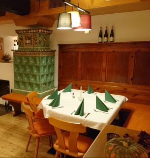 Photograph of a restaurant with a tiled stove and table setting
