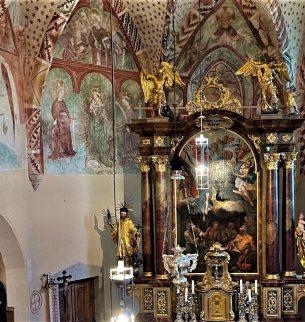 schön verzierte Kirchenwand, im Vordergrund steht ein großer Altar