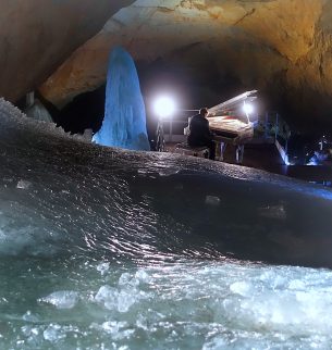 Photo of person playing piano in Parzival Dome in Dachstein Giant Ice Caves.