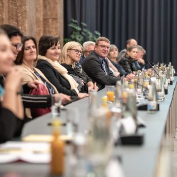 Mitglieder der Bruckner-Gemeinden, die an einem langen Tisch sitzen.