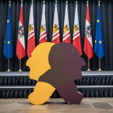 Bruckner-Doppelkopf aus Styropor vor Landes- und EU-Flaggen.