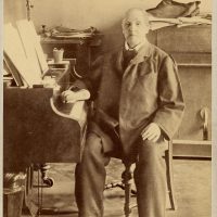 Historisches Foto von älterem Anton Bruckner an einem Klavier sitzend