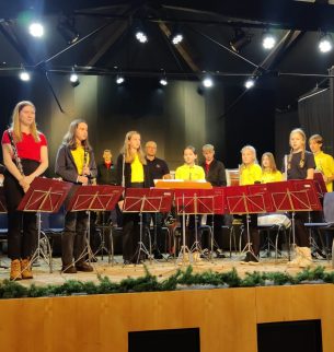 Youth orchestra on stage in red and yellow T-shirts